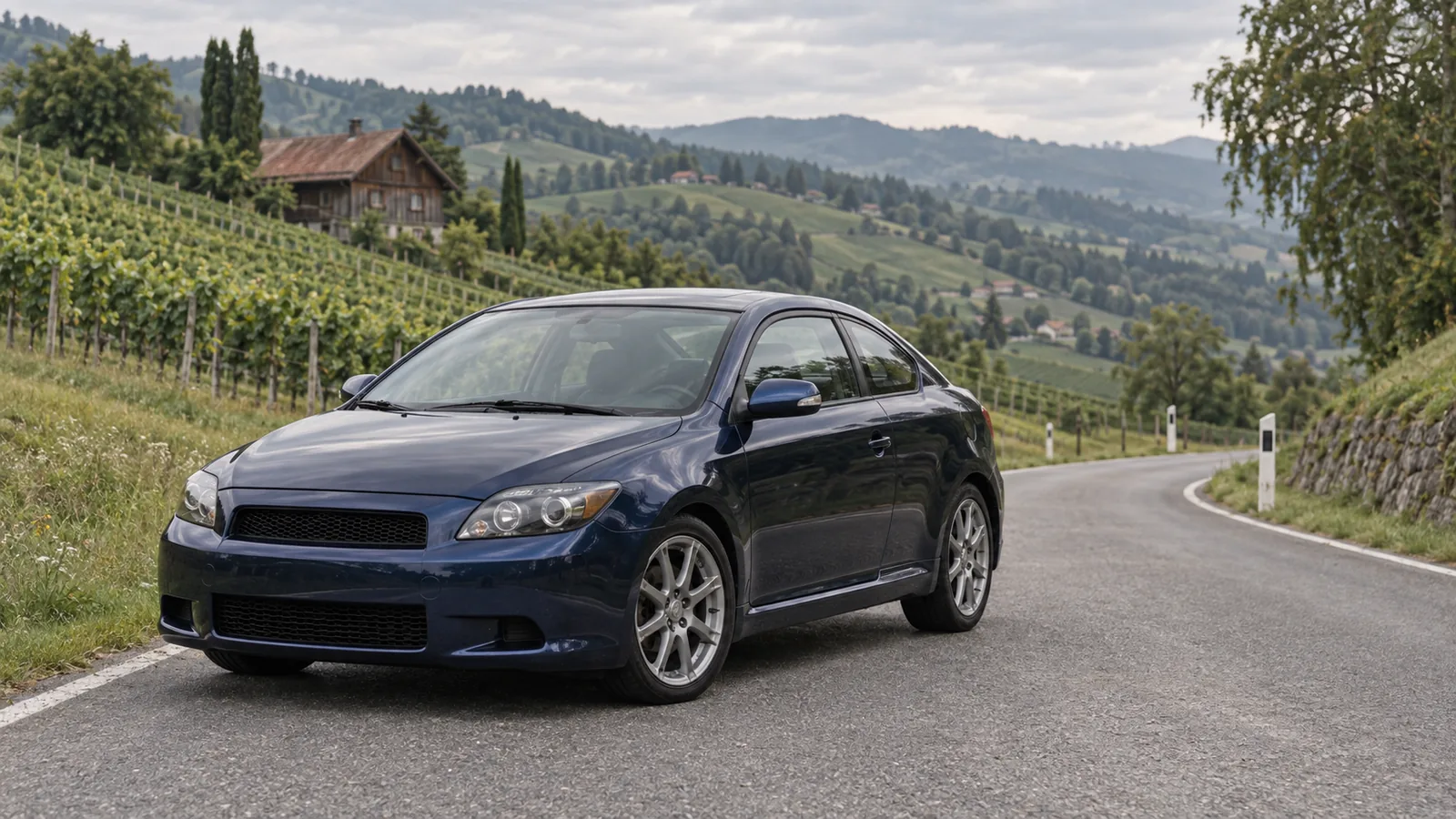 Dunkelblauer Scion tC der ersten Generation auf einer Landstraße zwischen Weinbergen in der Steiermark