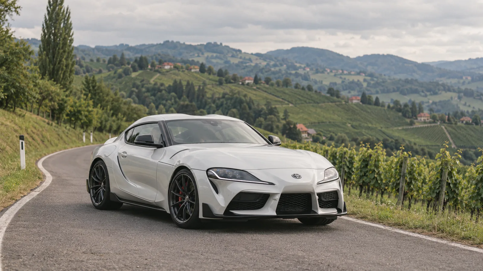 Weißer Toyota GR Supra (A90) auf einer Landstraße zwischen Weinbergen in der Steiermark