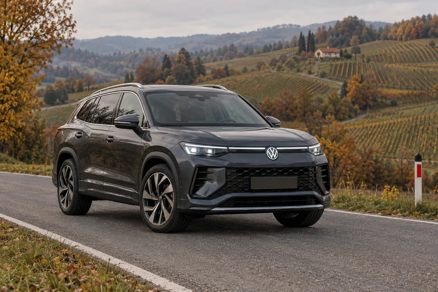 Dunkelgrauer VW Tayron auf einer Landstraße vor herbstlichen Weinbergen in der Steiermark